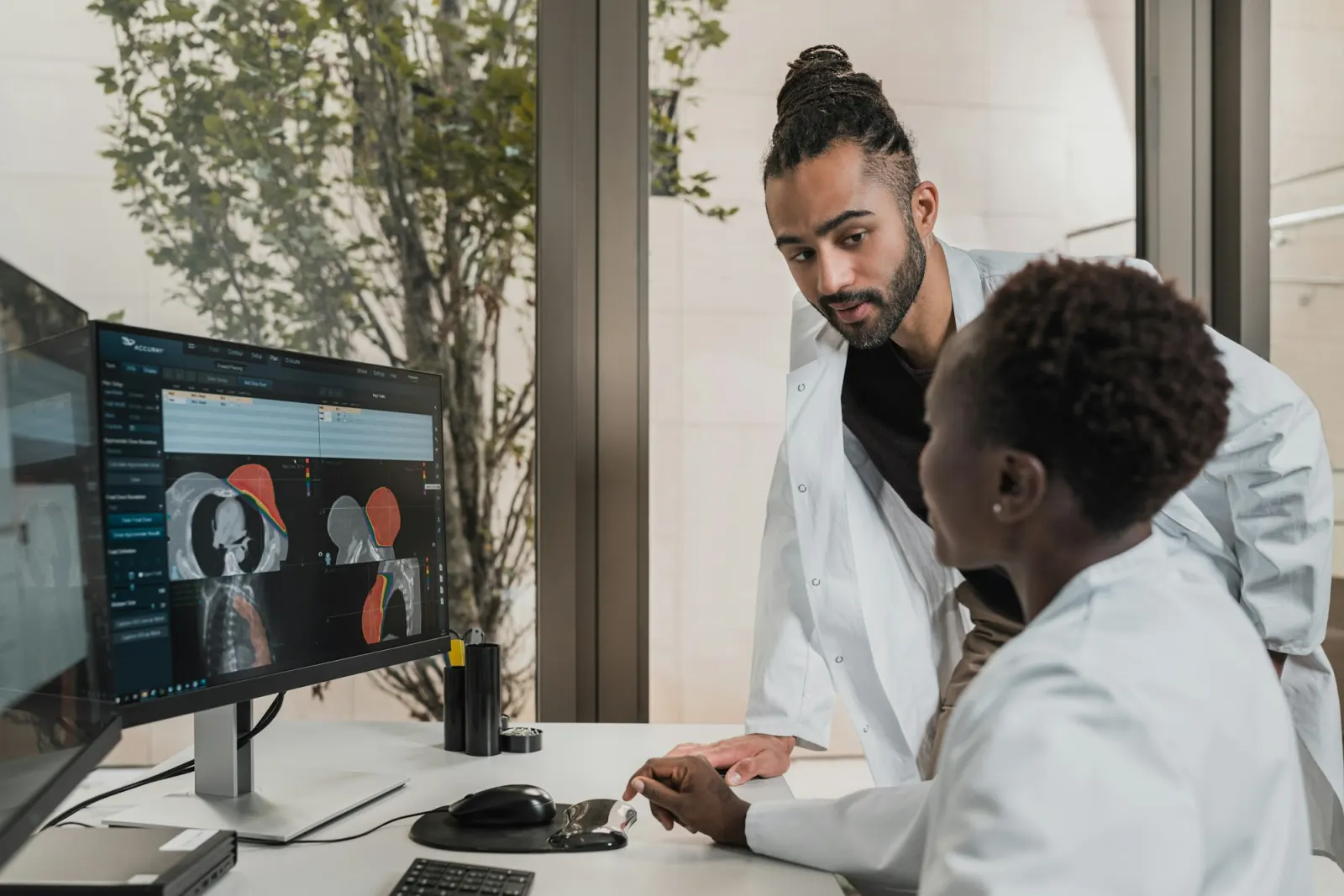 Two clinicians reviewing images on a monitor